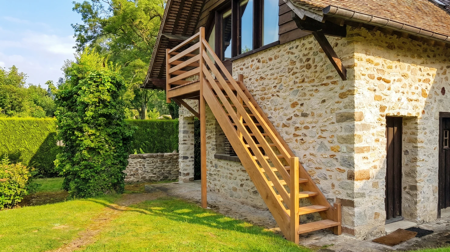 Escalier flottant moderne avec marches en bois massif fixées au mur, garde-corps en verre trempé